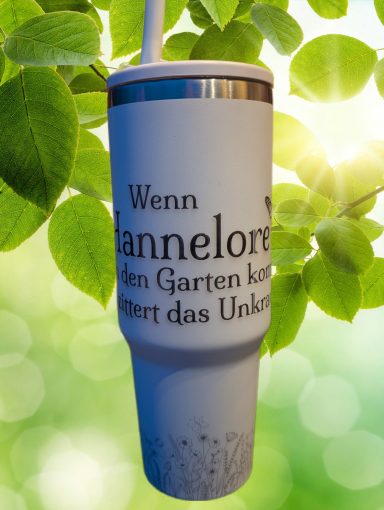 Becher mit dem Text „Wenn Hannelore im Garten ist, passiert das Unkeln.“ vor grünem Hintergrund.