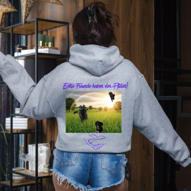 Frau trägt grauen Hoodie mit Regenbogen und Kühen auf der Rückseite.