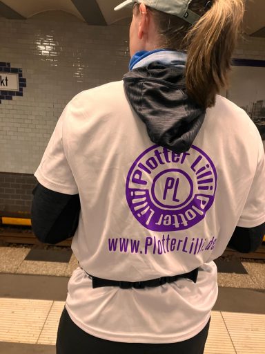 Eine Person trägt ein T-Shirt mit dem Logo "Plötzlicher Leben" und einer Website-Adresse.