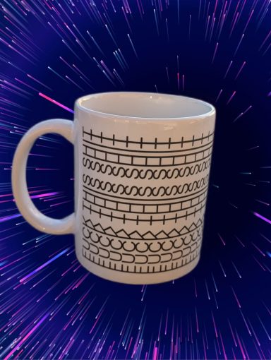 Weißer Kaffeebecher mit geometrischem, schwarzem Muster auf buntem Hintergrund.